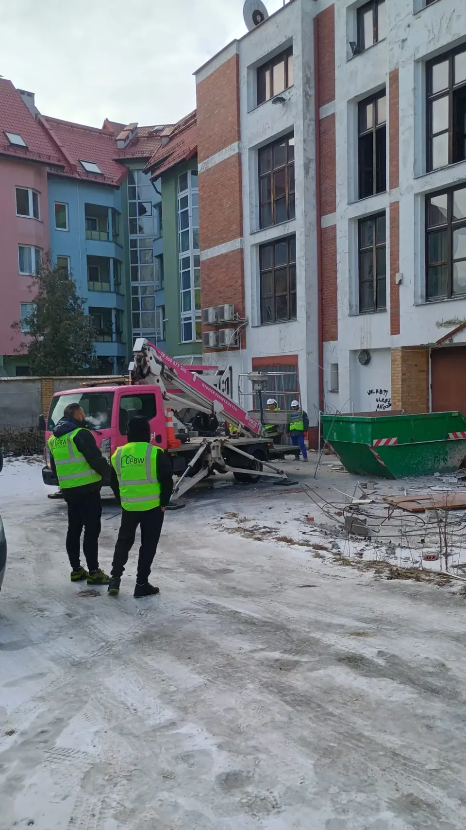 Samochód hakowy i kontener przy budynku